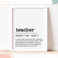 A framed print with definition of a teacher in dictionary style inside